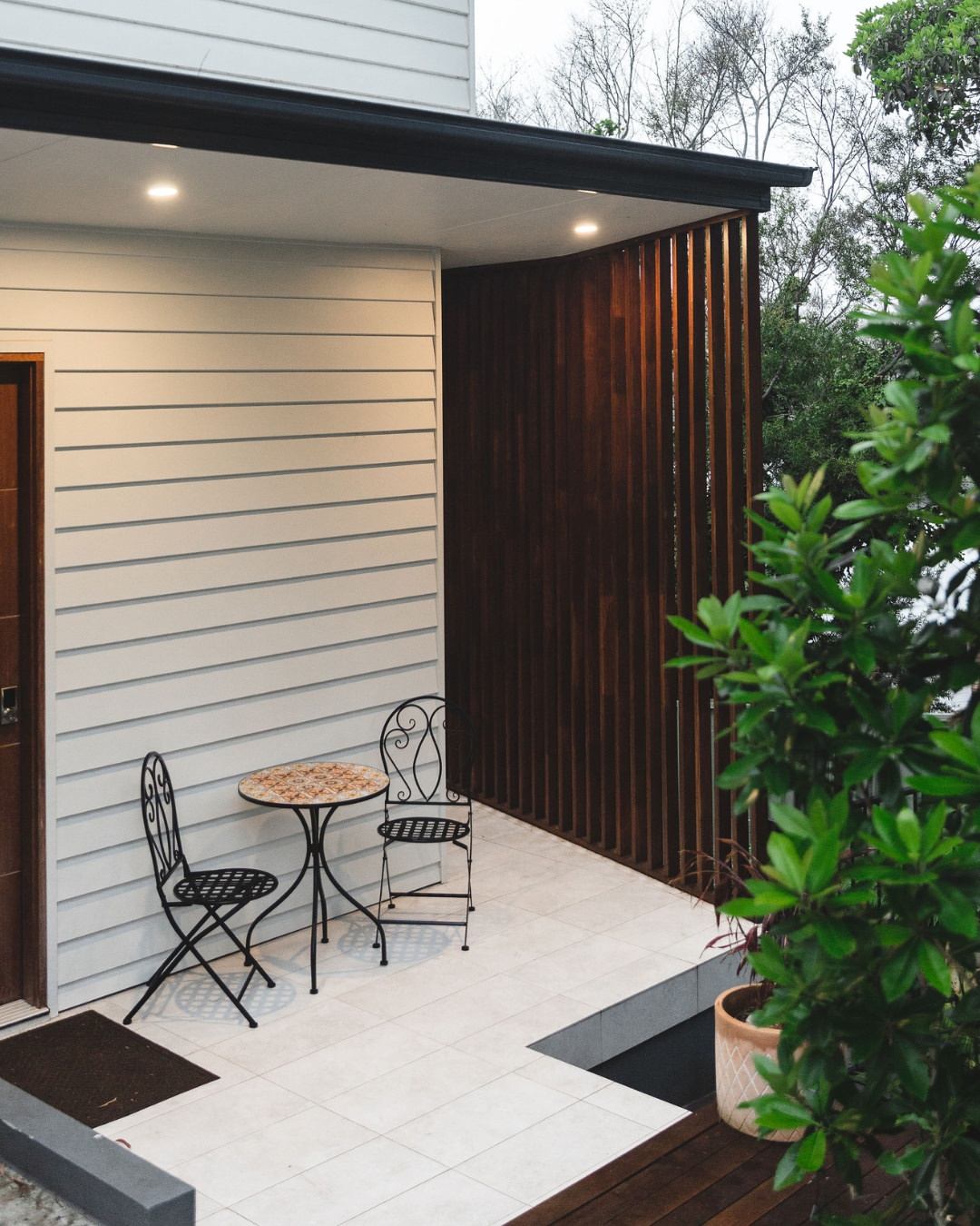 Completed CKS Projects home exterior showing a timber louvre screen, tiled outdoor area, and landscaped entry, representing the quality and detail that builder-led certification in Wollongong produces